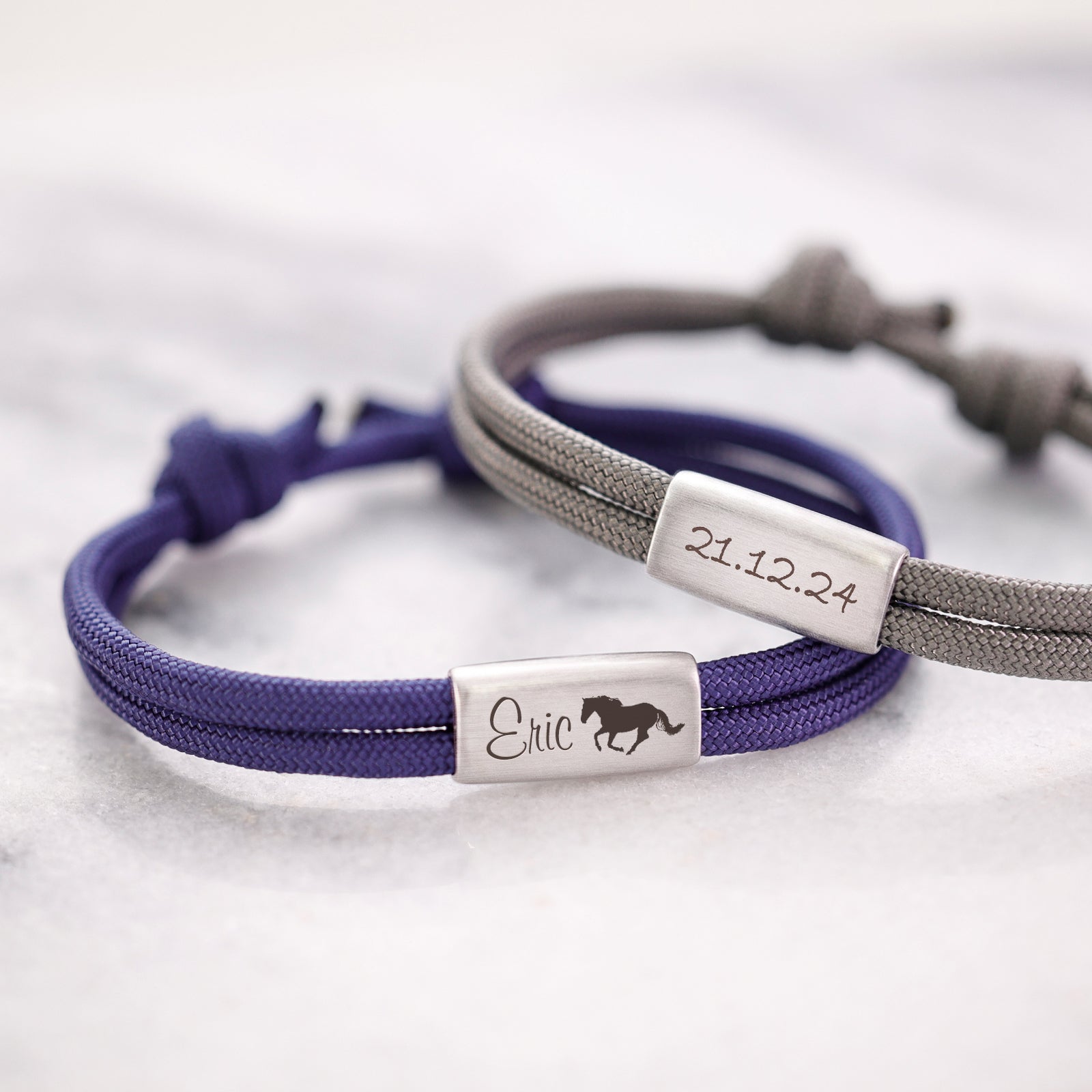 Personalisiertes Segeltau Armband mit Gravur zur Kommunion – lila Band mit Name und Pferdesymbol neben grauem Band mit Datum