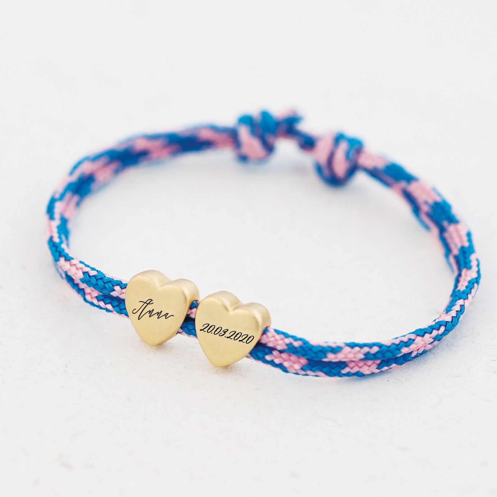 Herzarmband aus Segeltau in Blau-Rosa mit zwei goldenen Herzen – Name und Datum '20.03.2020' graviert