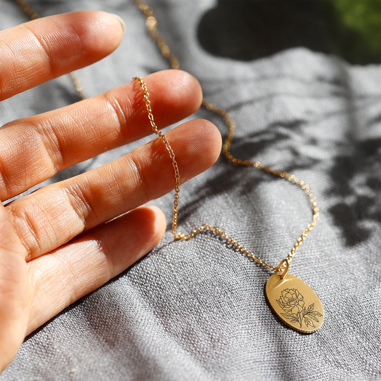 Personalized necklace with oval pendant and birth flowers