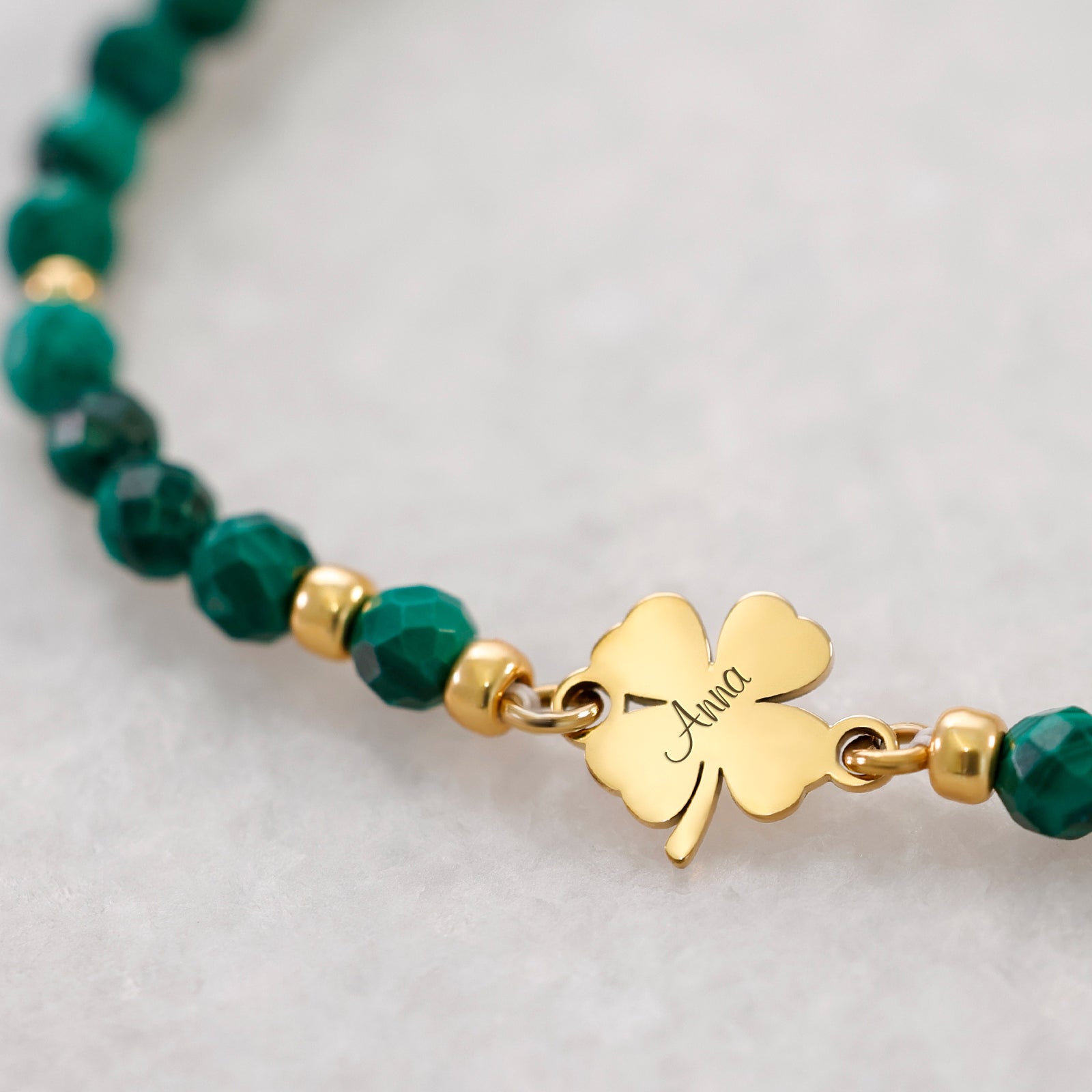Malachit-Armband mit Kleeblatt – Nahaufnahme des goldenen Kleeblattanhängers mit Gravur 'Anna'