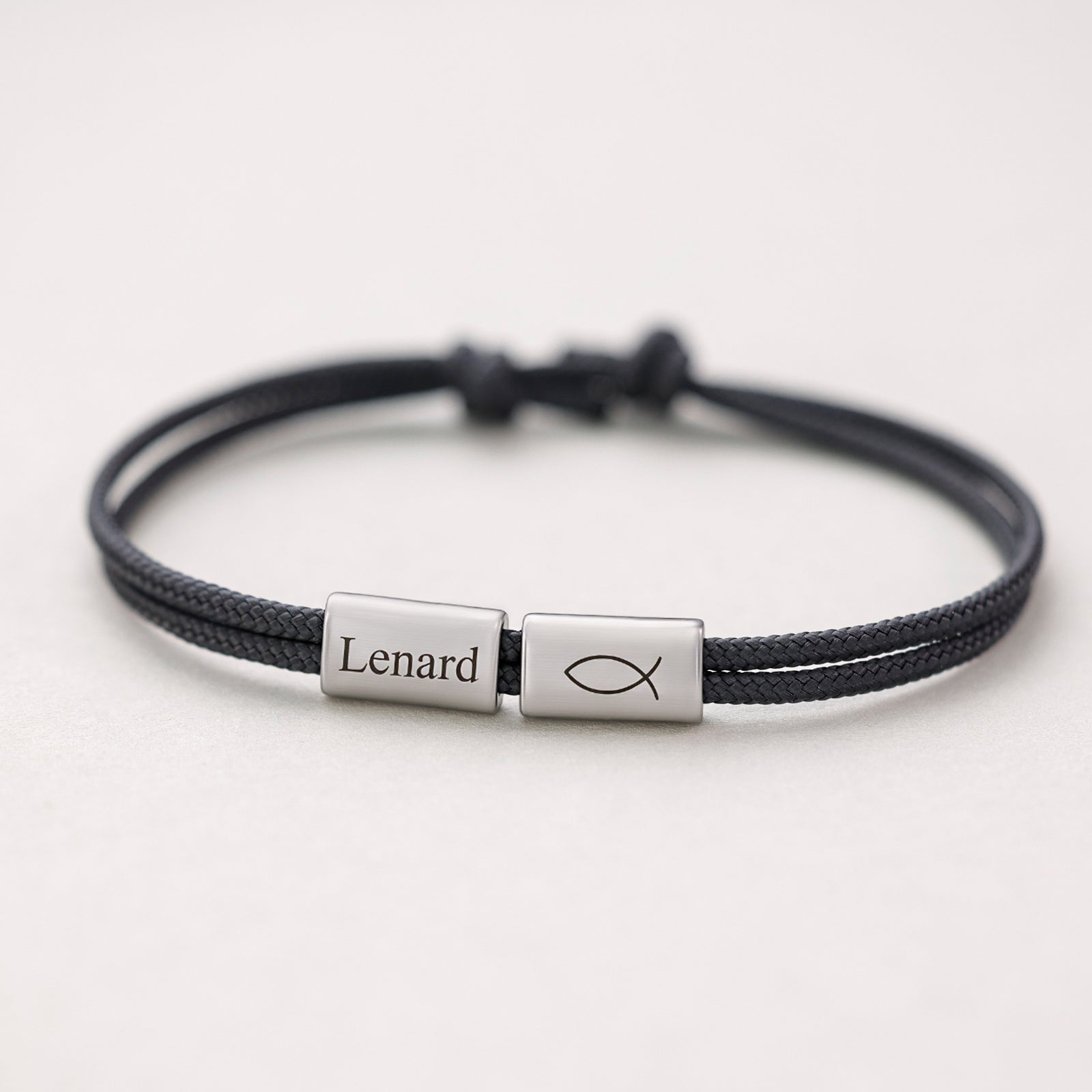 Segeltau Armband mit Gravur in Schwarz, silbernes Plättchen mit Namen und Fisch-Symbol