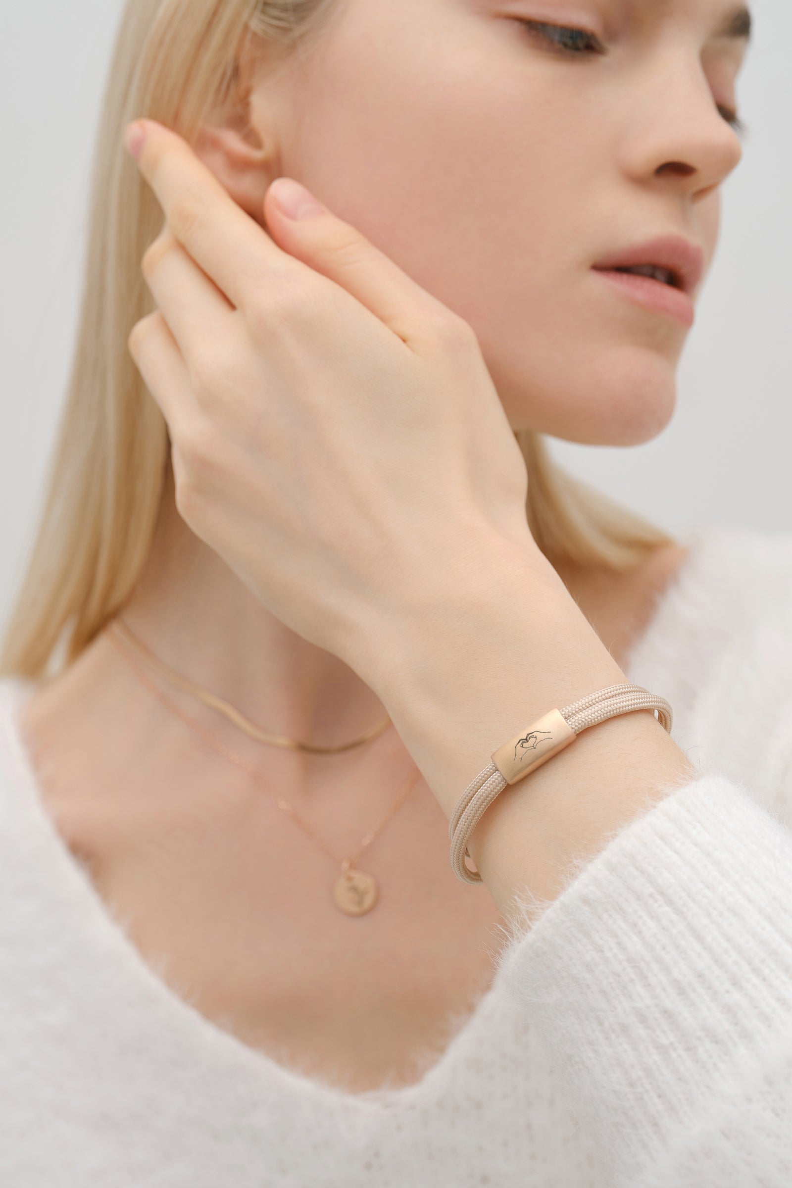 Frau trägt Segeltau Armband mit Wunschgravur in Beige, Plakette mit graviertem Bergsymbol