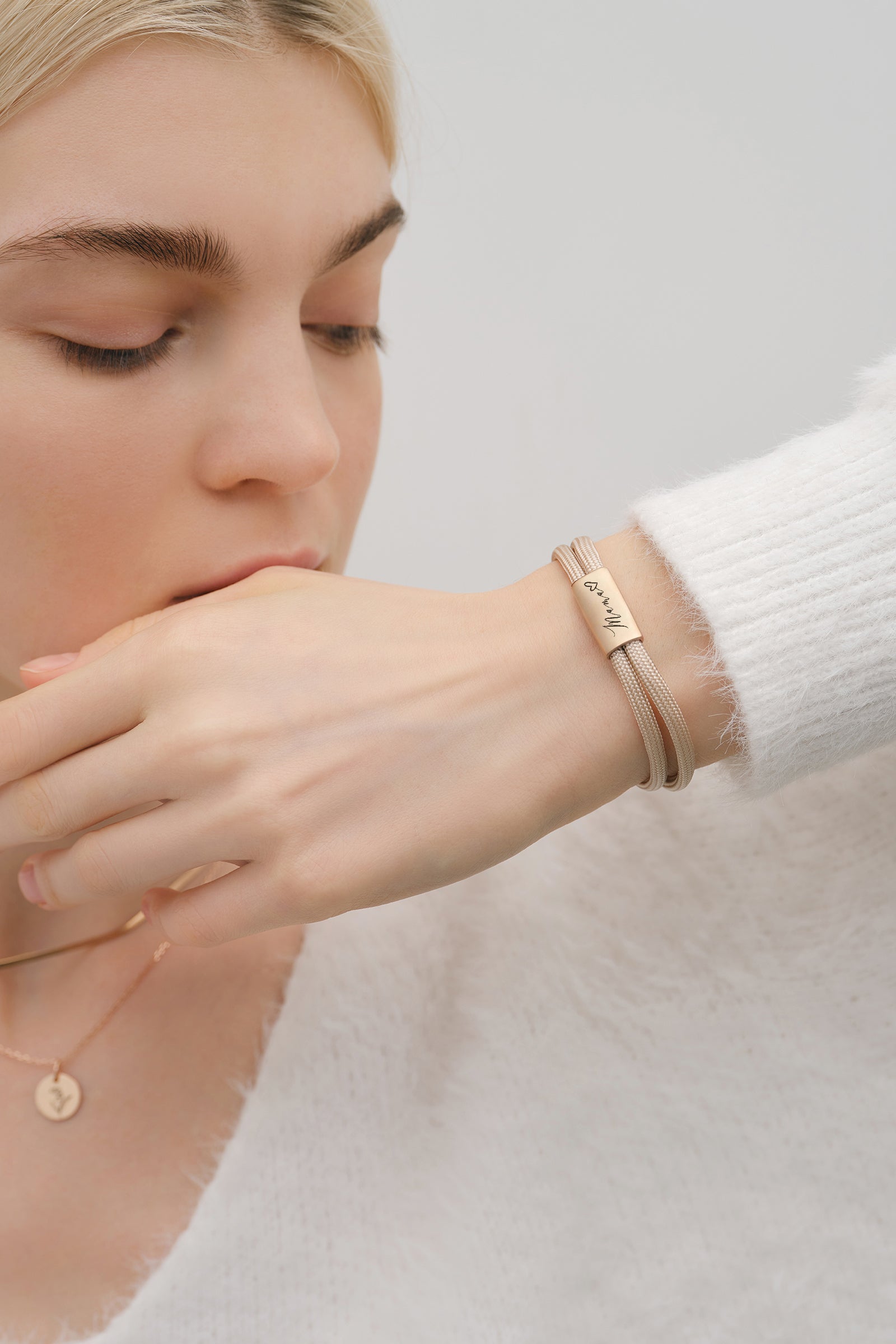 Frau trägt Segeltau Armband mit Wunschgravur in Beige, Plakette mit handschriftlicher Gravur